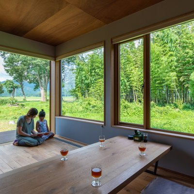 大きな開口部から山々の風景を眺める竹窓居